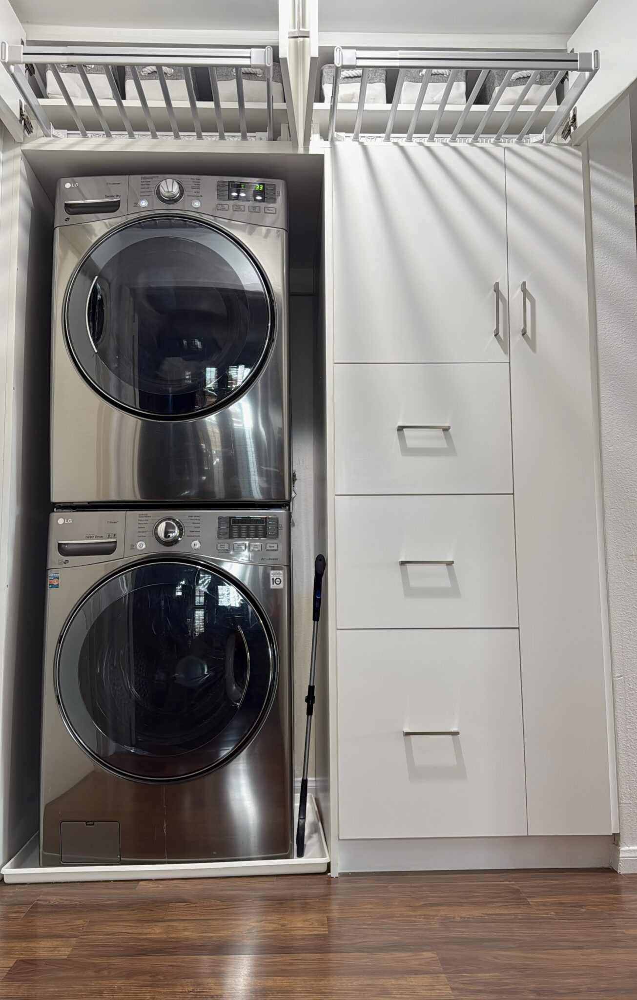 Laundry area with stacked washer and dryer and custom cabinets